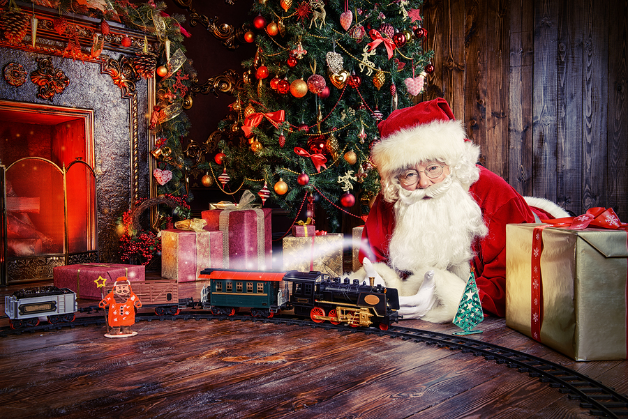 Happy Santa Claus playing with toys under the Christmas tree. Christmas concept. Magic time.